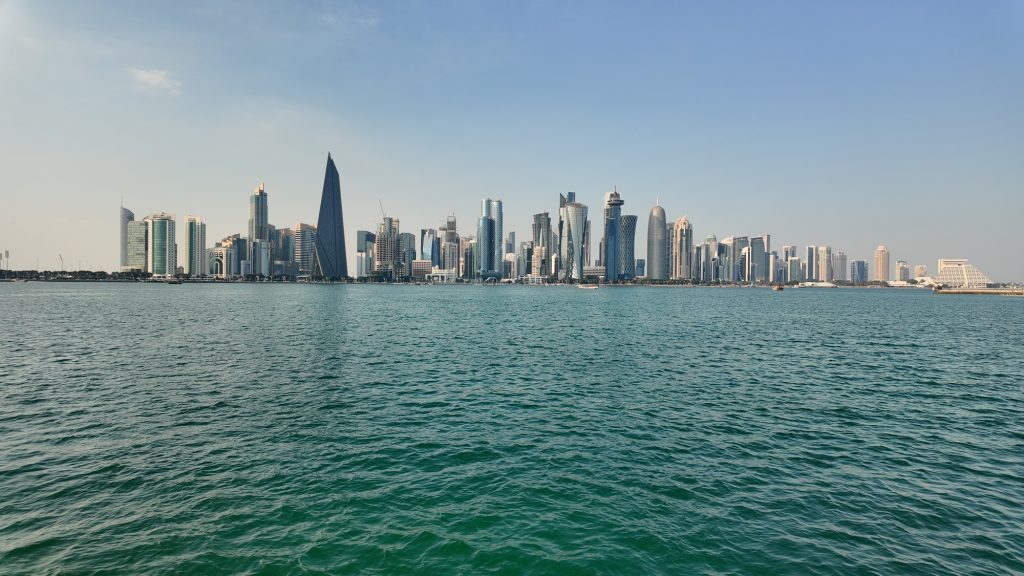 qatar doha 2 february 2025, City skyline reflects on calm waters at sunset in Doha, Qatar